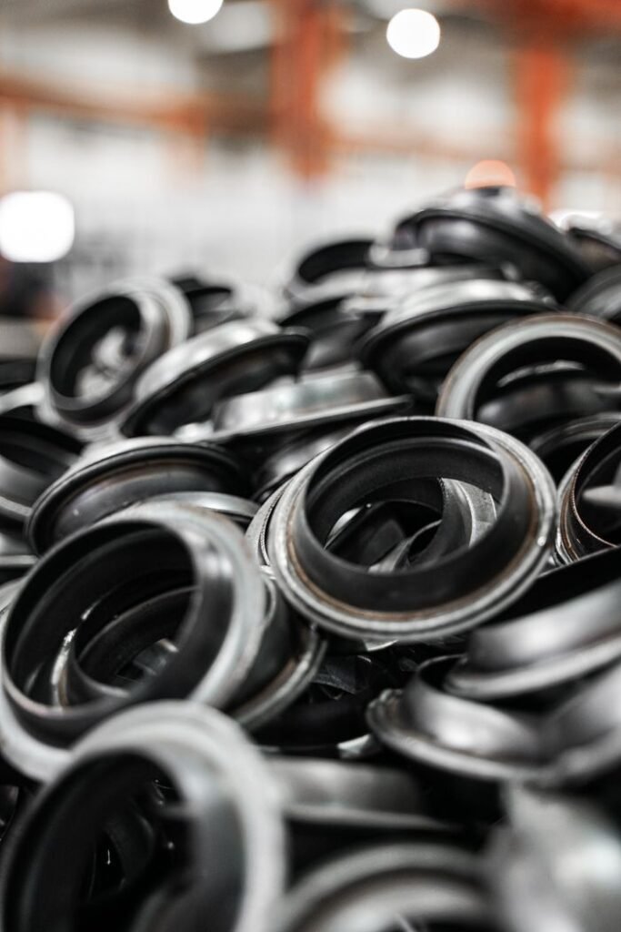 Close-up of a pile of black metal rings in a manufacturing environment.